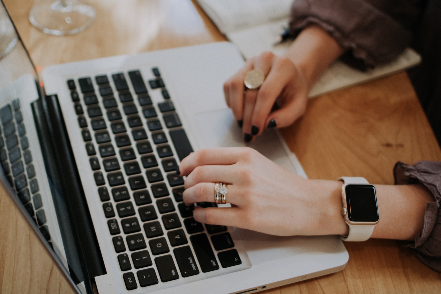 A close up shot of a woman hands working on a laptop